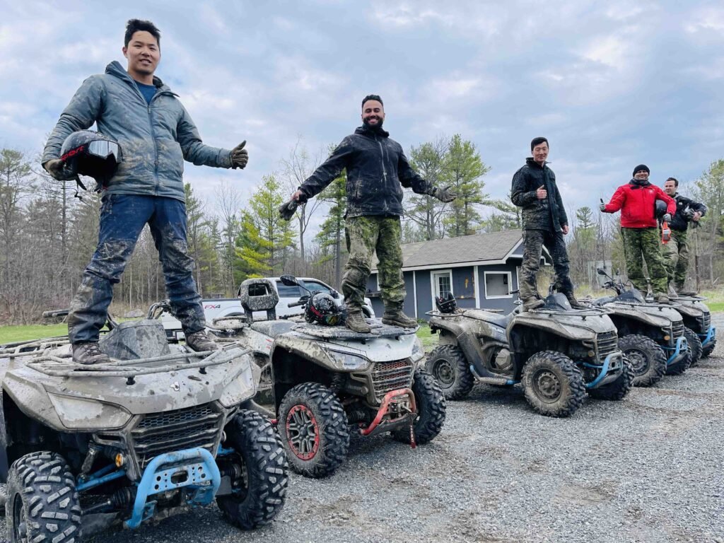 a group of guys standing on atv